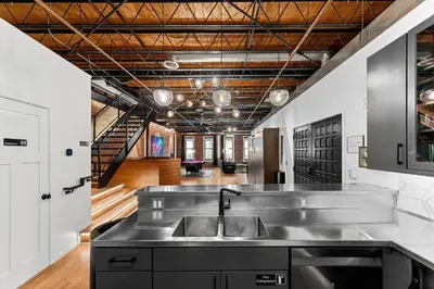 a kitchen with a stainless steel sink and a staircase at Hotel Residential of Denver in Denver