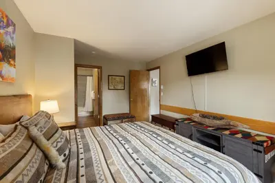 a bedroom with a bed and a flat screen tv at 309 Snowdance Manor condo in Keystone