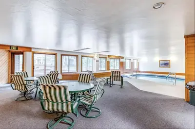 a room with a table and chairs and a swimming pool at 309 Snowdance Manor condo in Keystone