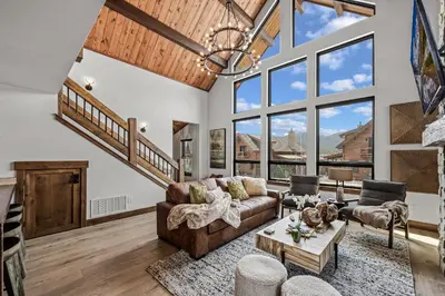 a living room with a couch and a table at Brand NEW Located on Lake Estes Private Jacuzzi Two Patios Indoor and Outdoor Fireplace in Estes Park