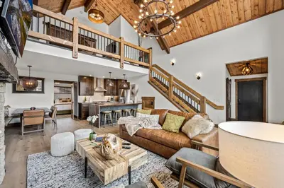 a living room with a couch and a table at Brand NEW Located on Lake Estes Private Jacuzzi Two Patios Indoor and Outdoor Fireplace in Estes Park