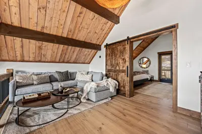 a living room with a couch and a table at Brand NEW Located on Lake Estes Private Jacuzzi Two Patios Indoor and Outdoor Fireplace in Estes Park