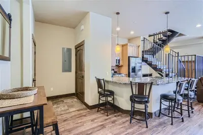 a kitchen and living room with a bar and chairs at Condos Off Main 15 condo in Frisco