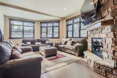 a living room with couches and a stone fireplace at Condos Off Main 15 condo in Frisco