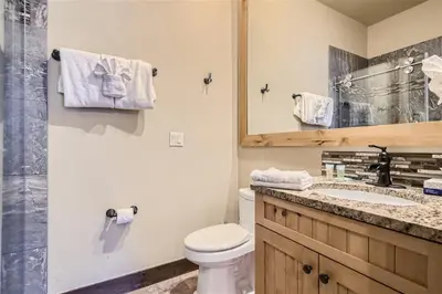 a bathroom with a toilet and a sink and a mirror at Condos Off Main 15 condo in Frisco