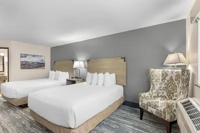 a hotel room with two beds and a chair at Best Western Alpenglo Lodge in Winter Park
