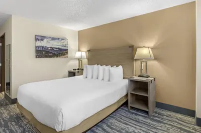 a hotel room with a large bed and two lamps at Best Western Alpenglo Lodge in Winter Park