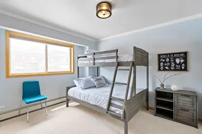 a bedroom with a bunk bed and a blue chair at Summit Sanctuary in Silverthorne