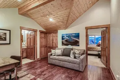 a living room with a couch and wooden ceilings at Drake Landing #A8 condo in Frisco