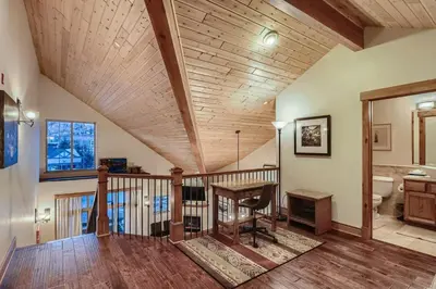 a living room with a wooden ceiling and a staircase at Drake Landing #A8 condo in Frisco