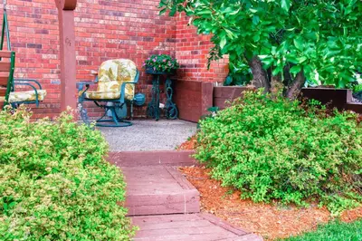 a garden with a chair and a brick wall at Charming Home with Yard about 12 Mi to Fort Collins in Loveland