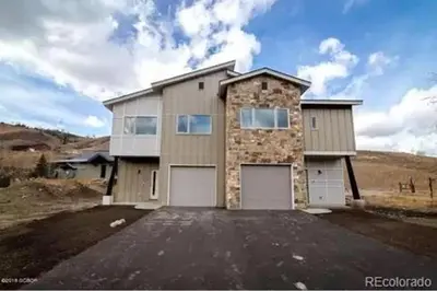 a large house with two garage doors in a driveway at 3BD/3BA- Updated Cozy Ski Retreat with Garage at the Base of Granby Ranch in Granby