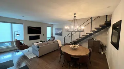 a living room with a couch and a table and a staircase at 3BD/3BA- Updated Cozy Ski Retreat with Garage at the Base of Granby Ranch in Granby