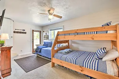 a bedroom with two bunk beds and a ceiling fan at Walk to Water Grand Lake Home with Hot Tub! in Grand Lake