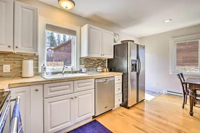 a kitchen with white cabinets and a stainless steel refrigerator at Walk to Water Grand Lake Home with Hot Tub! in Grand Lake