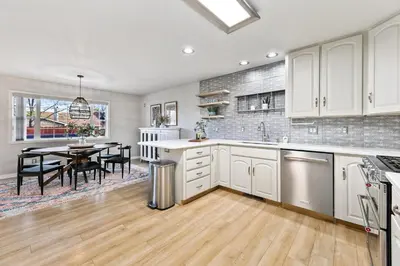a kitchen with white cabinets and a dining table at Scandinavian Chic - Hot Tub, Bikes and Lake Life! in Loveland