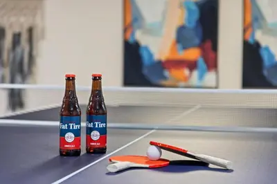 two bottles of beer sitting on a ping pong table at Scandinavian Chic - Hot Tub, Bikes and Lake Life! in Loveland