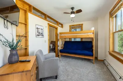 a bedroom with a bunk bed and a chair at Three-Bedroom Apartment in Keystone