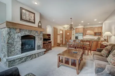 a living room with a stone fireplace and a table at One-Bedroom Apartment in Dillon