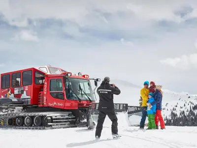 a group of people standing in the snow next to a truck at One-Bedroom Apartment in Dillon