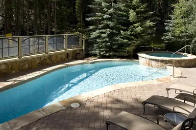 a large swimming pool with chairs next to a patio at One-Bedroom Apartment in Dillon