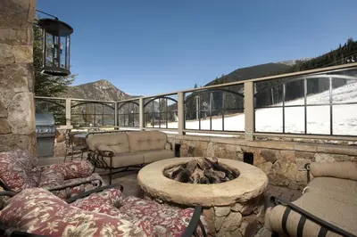 a patio with a fire pit and chairs and a mountain at One-Bedroom Apartment in Dillon
