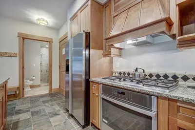 a kitchen with wooden cabinets and a stainless steel refrigerator at One-Bedroom Apartment in Dillon