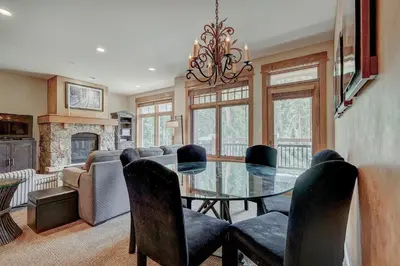 a dining room with a glass table and chairs at Luxurious 2 BR in River Run Village with Ski in ski out, Kids Ski Free condo in Dillon