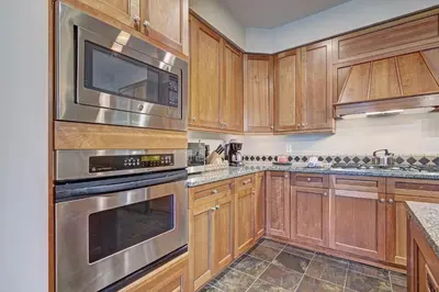 a kitchen with wooden cabinets and stainless steel appliances at Luxury 3 BR in River Run Village Featuring Ski in, ski out! condo in Dillon