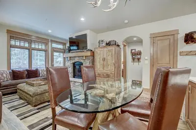 a dining room with a glass table and a fireplace at One-Bedroom Apartment in Dillon
