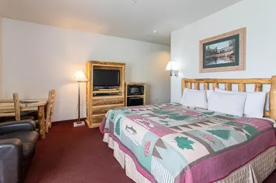 a bedroom with a bed and a desk and a television at North Park Inn & Suites in Walden