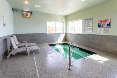 a swimming pool in a room with a chair and a table at North Park Inn & Suites in Walden