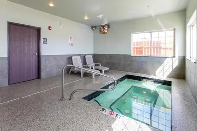 a hot tub in a waiting room with two chairs at North Park Inn & Suites in Walden