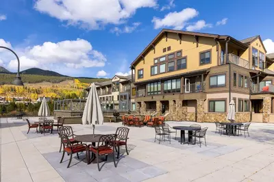 a patio with tables and chairs in front of a building at 2767 Slopeside condo in Keystone