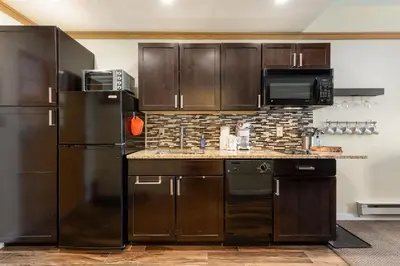 a kitchen with black appliances and brown cabinets at 2767 Slopeside condo in Keystone