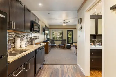 a kitchen with black cabinets and a dining room at 2767 Slopeside condo in Keystone