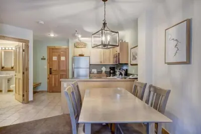 a kitchen and dining room with a table and chairs at 1 Bedroom Mountain Condo In River Run Village With Expansive Mountain Views And Walking Distance To Ski Slopes in Keystone