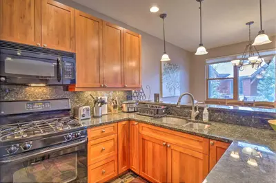 a kitchen with wooden cabinets and stainless steel appliances at 5 Mi to Breckenridge Skiing Mtn Gem with Hot Tub! in Breckenridge
