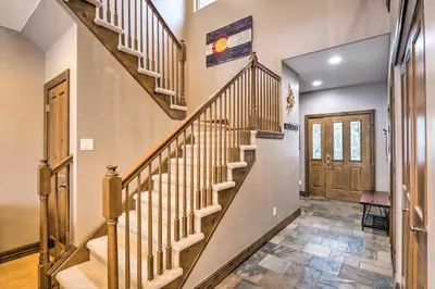 a staircase in a home with wooden railings at 5 Mi to Breckenridge Skiing Mtn Gem with Hot Tub! in Breckenridge