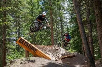 two people on dirt bikes jumping over a ramp at Luxurious 1 BR in River Run Village with Ski in ski out condo in Dillon