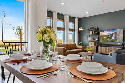 a dining room with a table with a vase of flowers at Spacious Home, Great Backyard with Mtn Sunset Views! in Loveland