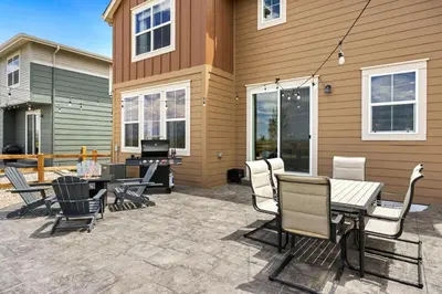 a patio with chairs and a table and a television at Spacious Home, Great Backyard with Mtn Sunset Views! in Loveland
