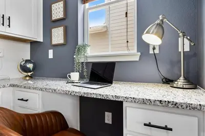 a laptop computer sitting on a counter in a kitchen at Spacious Home, Great Backyard with Mtn Sunset Views! in Loveland