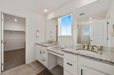 a white bathroom with two sinks and a window at Spacious Home, Great Backyard with Mtn Sunset Views! in Loveland