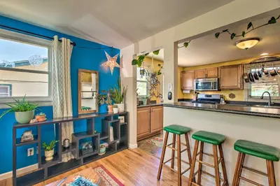 a kitchen with blue walls and green bar stools at Patio, Grill and Yard Cozy Denver Abode! in Denver