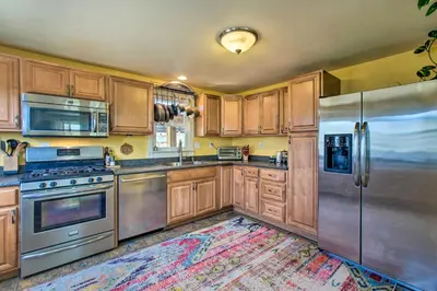 a kitchen with wooden cabinets and stainless steel appliances at Patio, Grill and Yard Cozy Denver Abode! in Denver