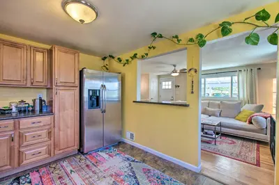 a kitchen with a refrigerator and a living room at Patio, Grill and Yard Cozy Denver Abode! in Denver