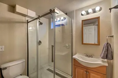 a bathroom with a shower and a toilet and a sink at Patio, Grill and Yard Cozy Denver Abode! in Denver