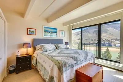 a bedroom with a bed and a large window at Mtn and Reservoir Views Cozy Dillon Condo! in Dillon