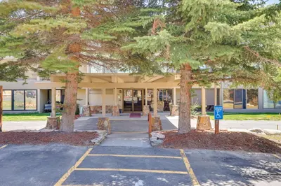 a building with two trees in front of it at Mtn and Reservoir Views Cozy Dillon Condo! in Dillon